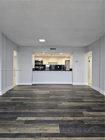 a view of a kitchen and an empty room