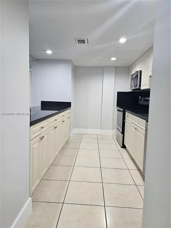 a large white kitchen with a sink and cabinets