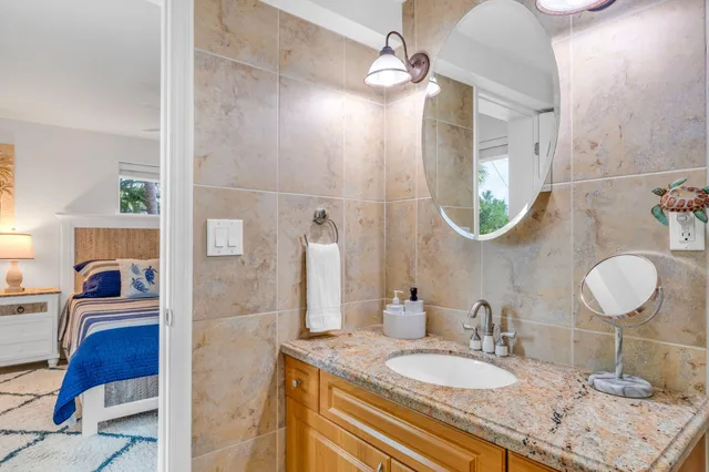 a bathroom with a granite countertop sink a mirror and vanity