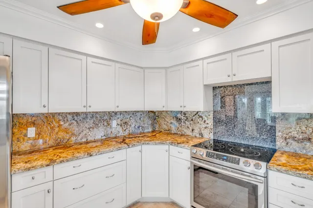 a kitchen with a stove and white cabinets