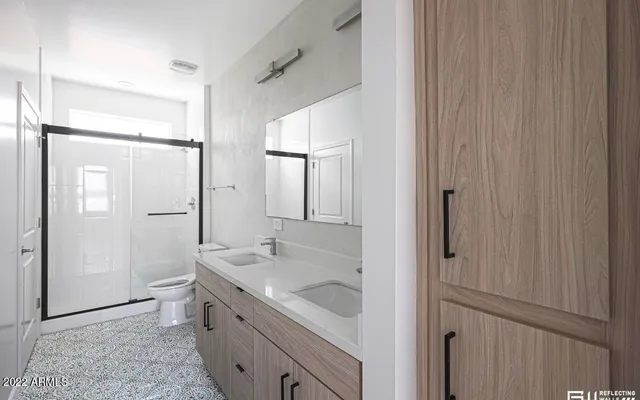 a spacious bathroom with a shower sink and mirror