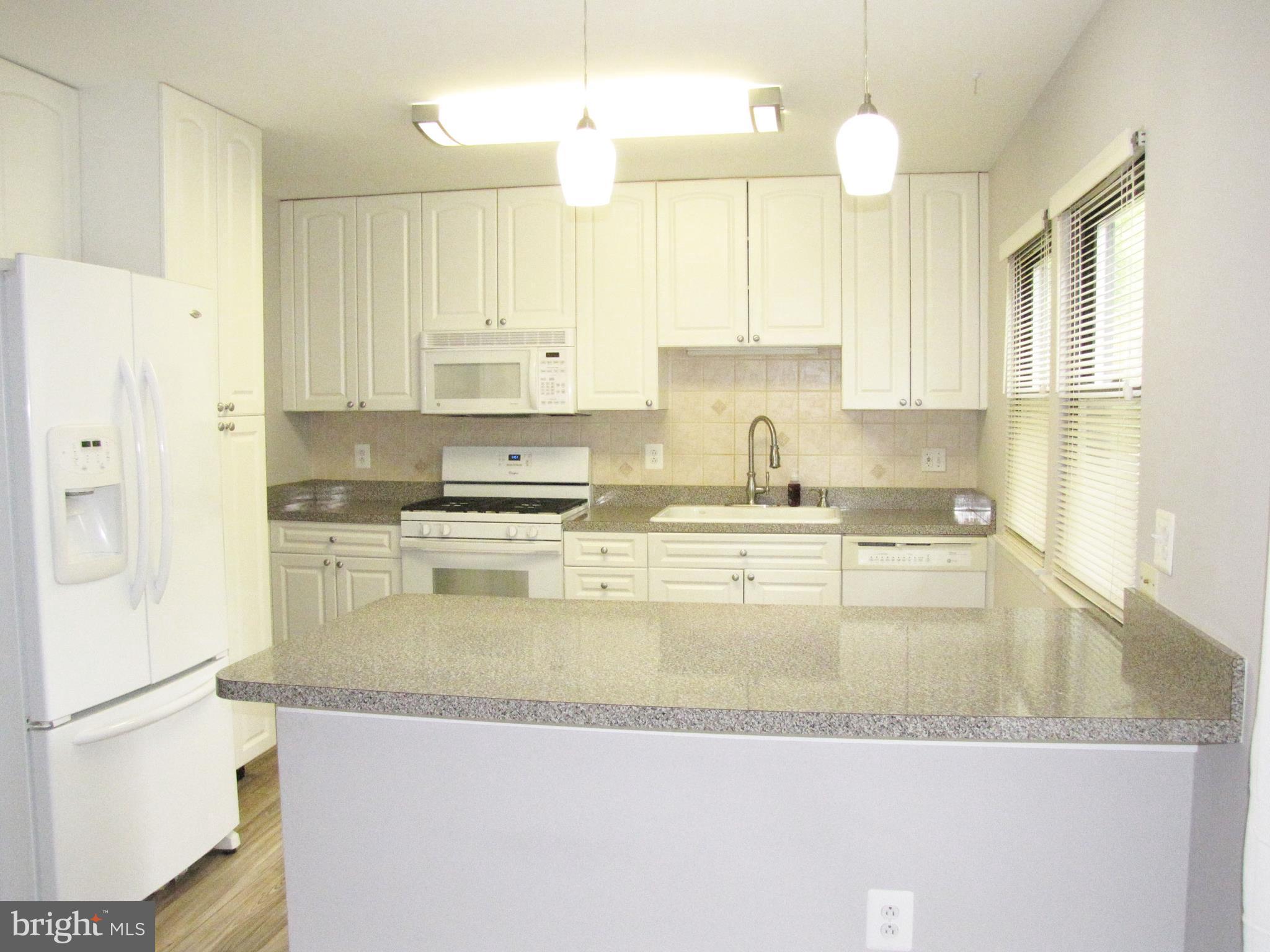 9600 Farewell Road Columbia, MD 21045 - Photo 7 of 18 a large kitchen with granite countertop a sink a center island stainless steel appliances and a cabinets