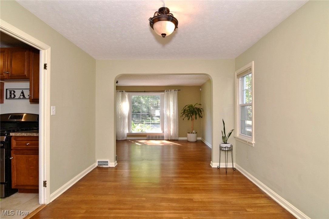 3679 Fenley Road Cleveland Heights, OH 44121 - Photo 11 of 45 Corridor with arched walkways, healthy amount of natural light, light wood-type flooring, and a textured ceiling