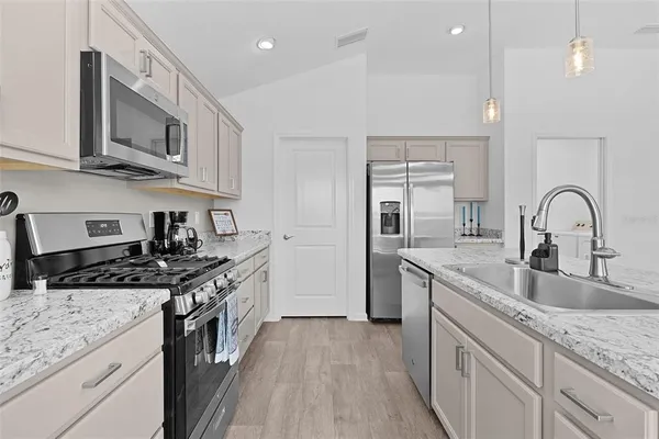 a kitchen with stainless steel appliances granite countertop a sink stove and cabinets