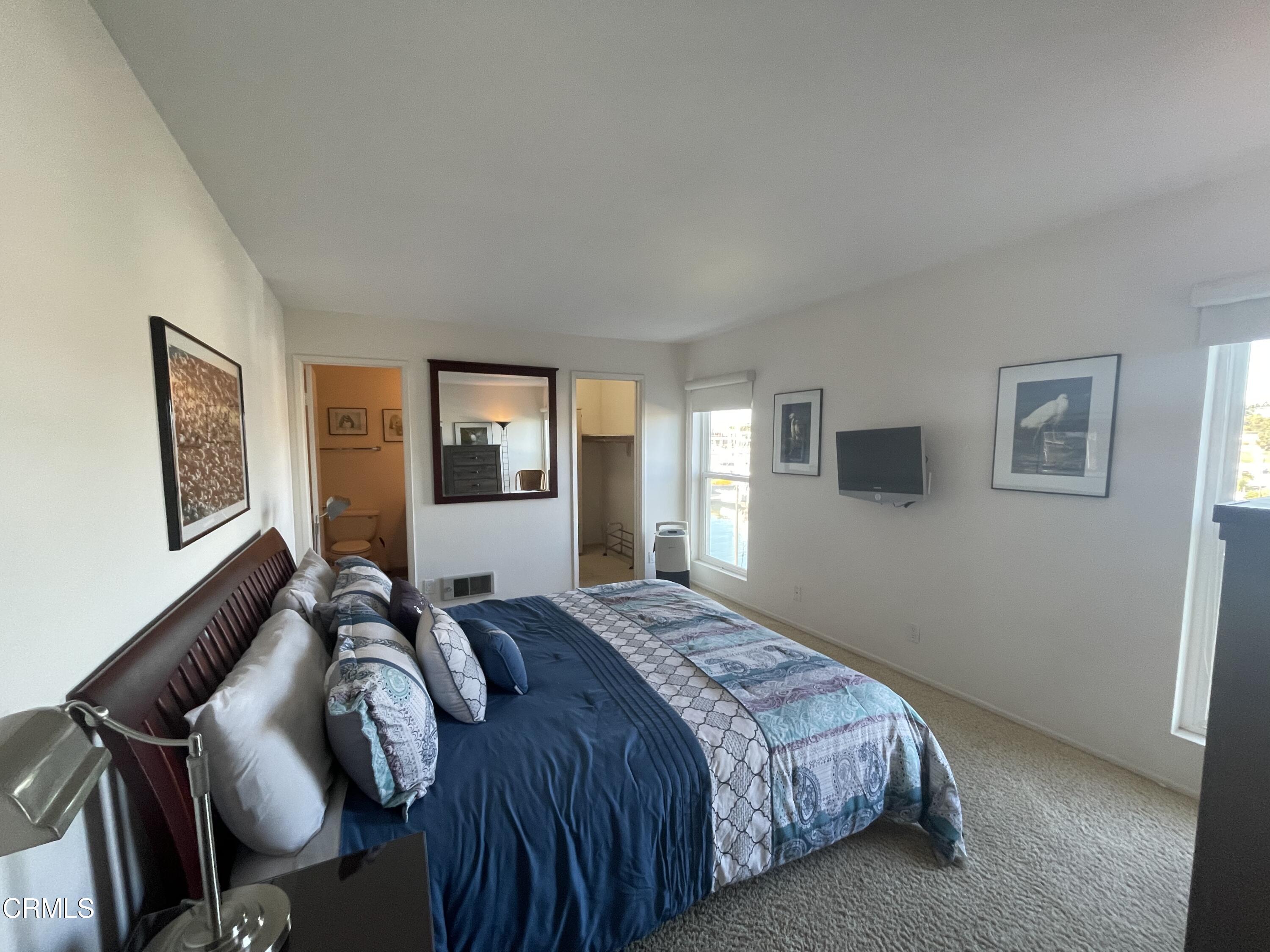 2901 Peninsula Road, Unit 144 Oxnard, CA 93035 - Photo 17 of 25 a bedroom with a bed and wooden floor