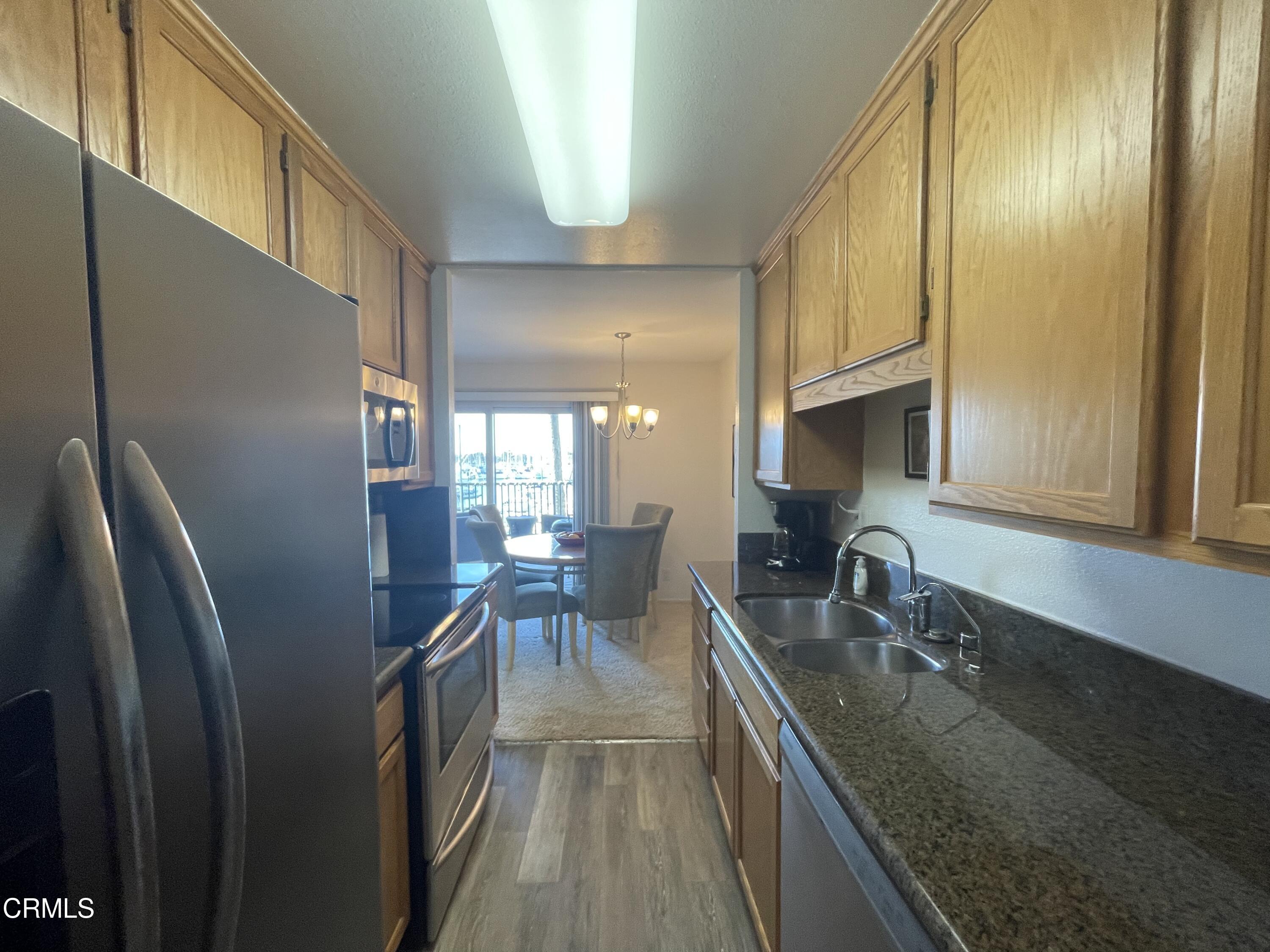 2901 Peninsula Road, Unit 144 Oxnard, CA 93035 - Photo 9 of 25 a kitchen with stainless steel appliances granite countertop a sink a stove and a refrigerator