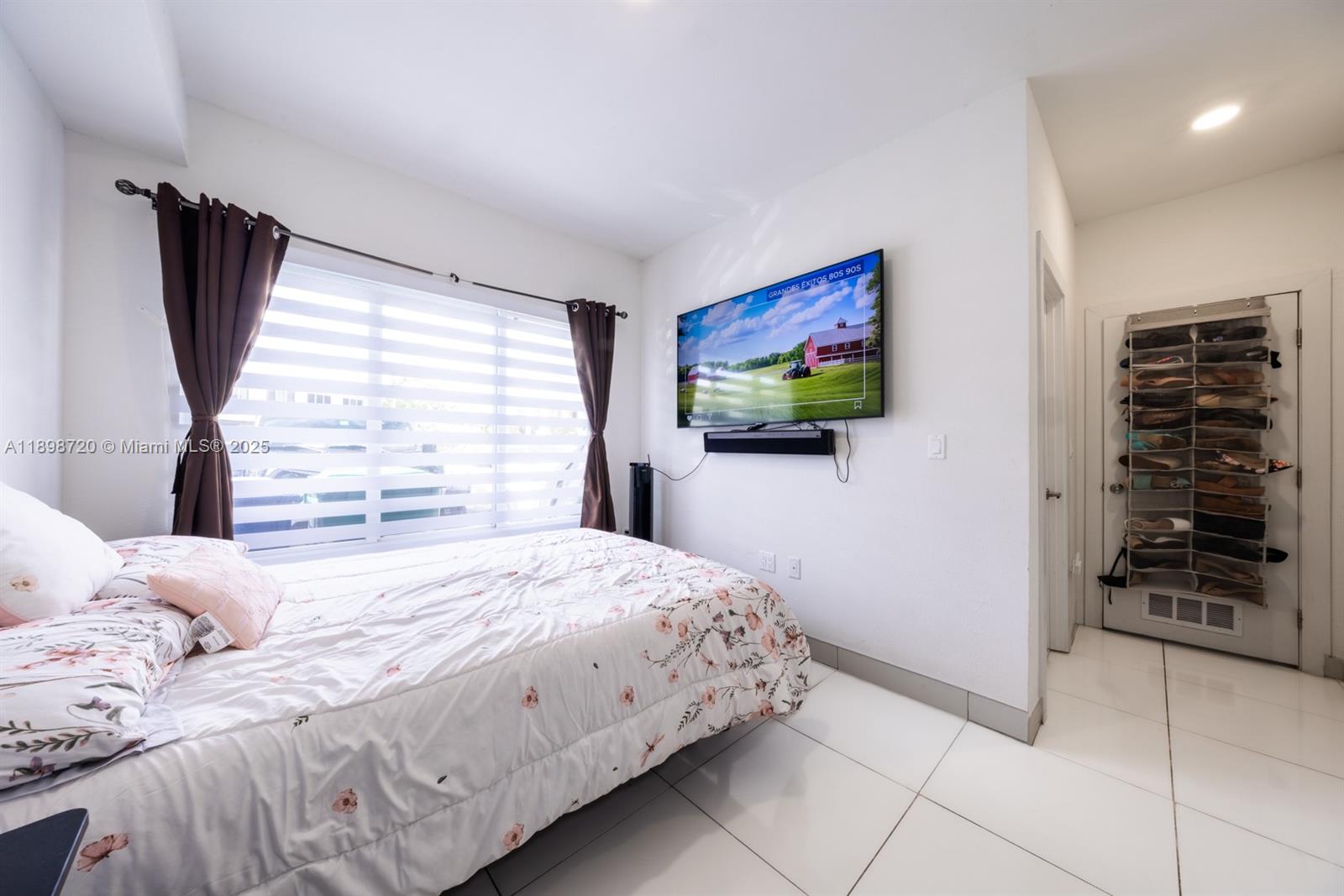 13966 Southwest 258th Street Homestead, FL 33032 - Photo 15 of 23 a bedroom with a bed and a flat screen tv