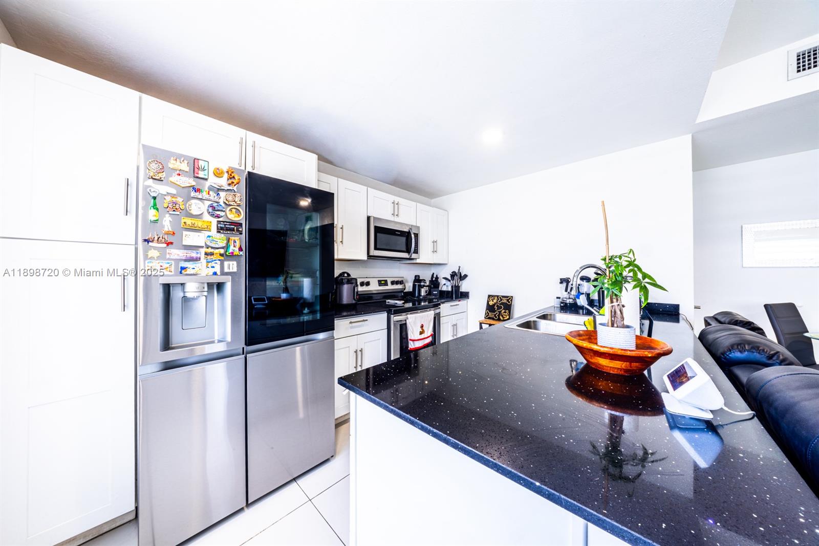 13966 Southwest 258th Street Homestead, FL 33032 - Photo 18 of 23 a kitchen with stainless steel appliances kitchen island granite countertop a refrigerator and a stove top oven