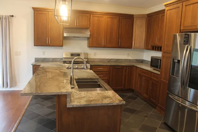 a bathroom with a granite countertop sink and a mirror
