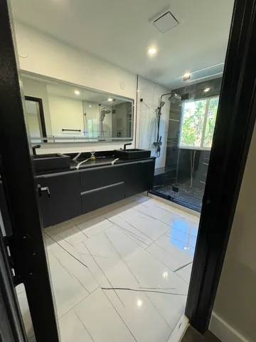 a view of a yard with large trees and a wooden fence