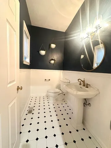 a bathroom with a sink a toilet and a mirror