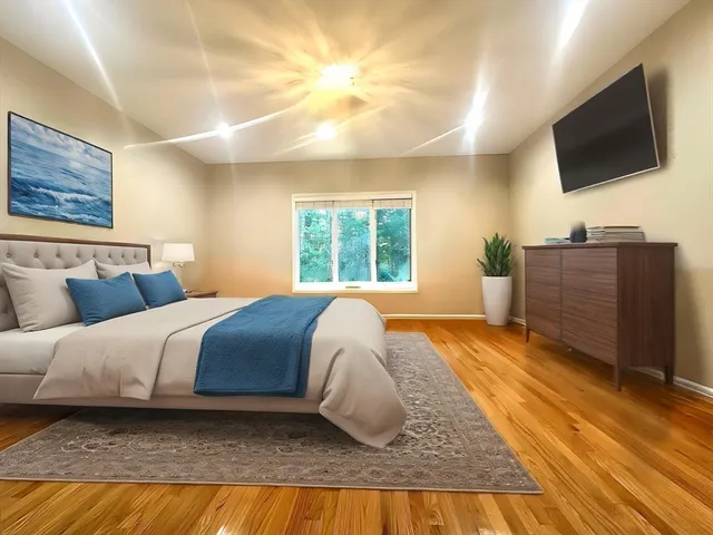 a bedroom with a large bed and a flat screen tv