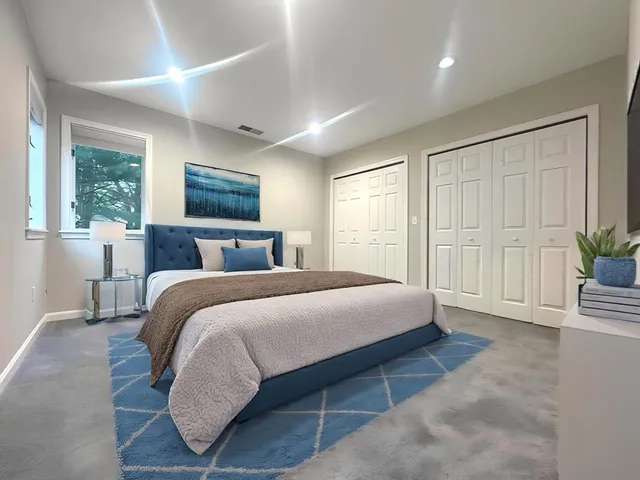 a bedroom with a large bed and a potted plant