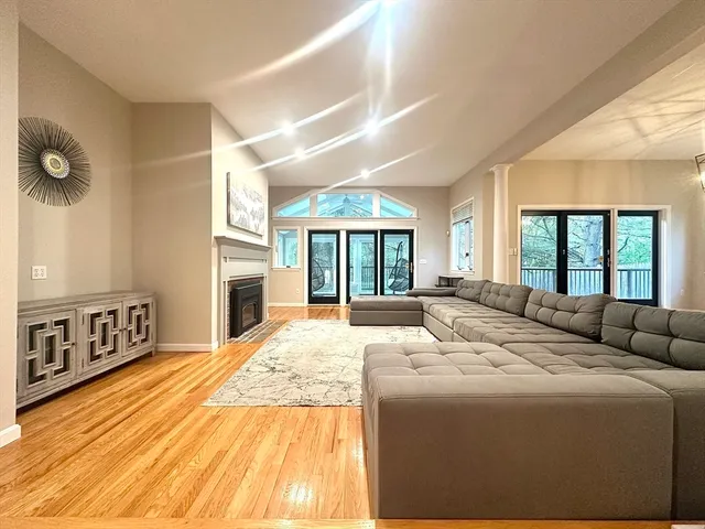 a living room with large windows and a fireplace