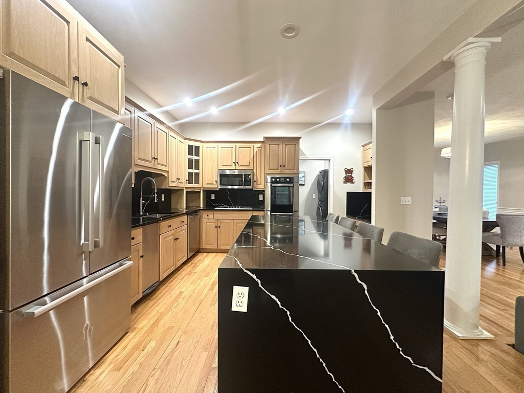 104 Channing Road Concord, MA 01742 - Photo 7 of 28 a view of a kitchen with refrigerator stove and wooden floor