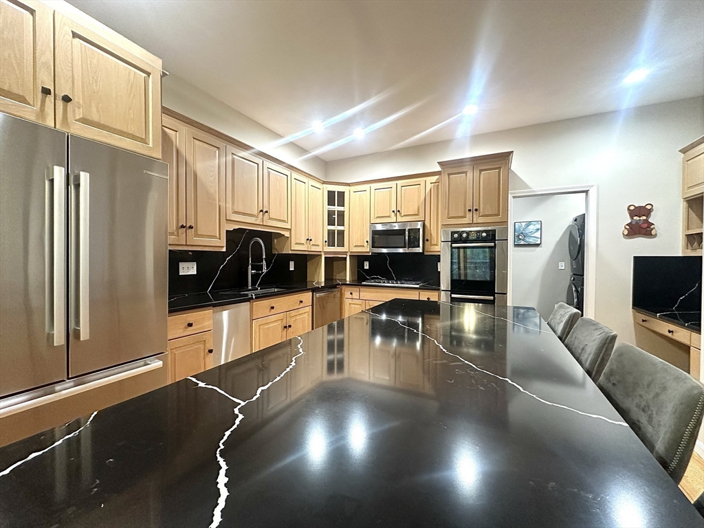 104 Channing Road Concord, MA 01742 - Photo 8 of 28 a kitchen with stainless steel appliances a refrigerator a stove a sink a dining table and chairs with wooden floor