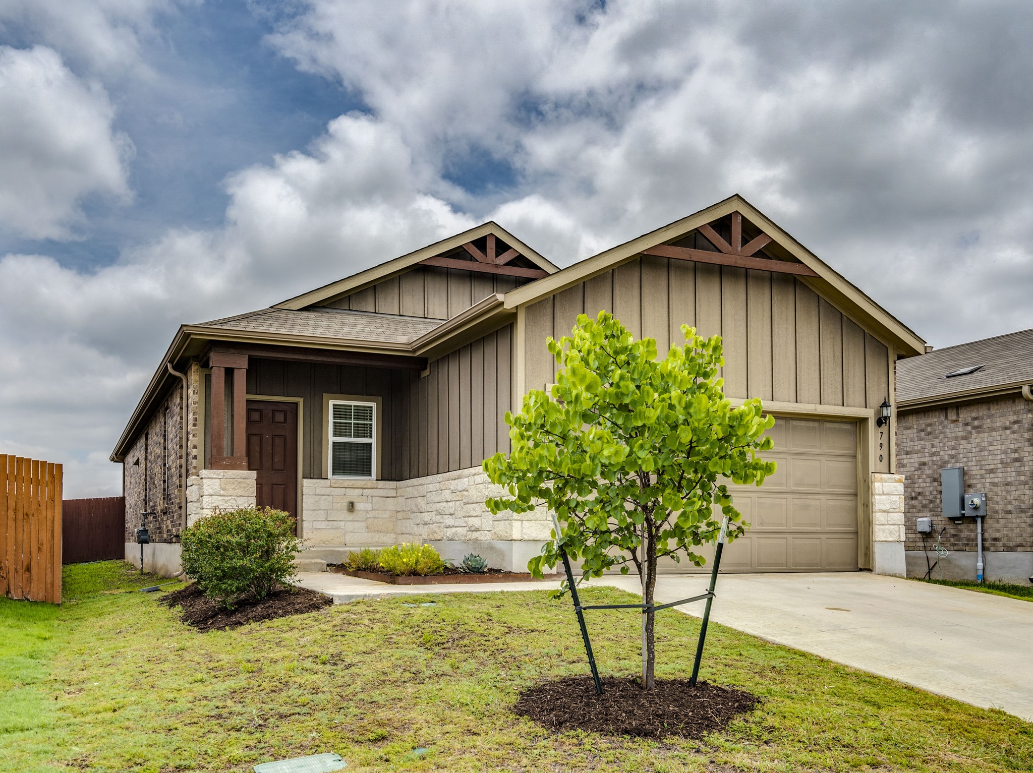 A welcoming facade showcases mixed materials, an inviting entry, and a well-maintained lawn.