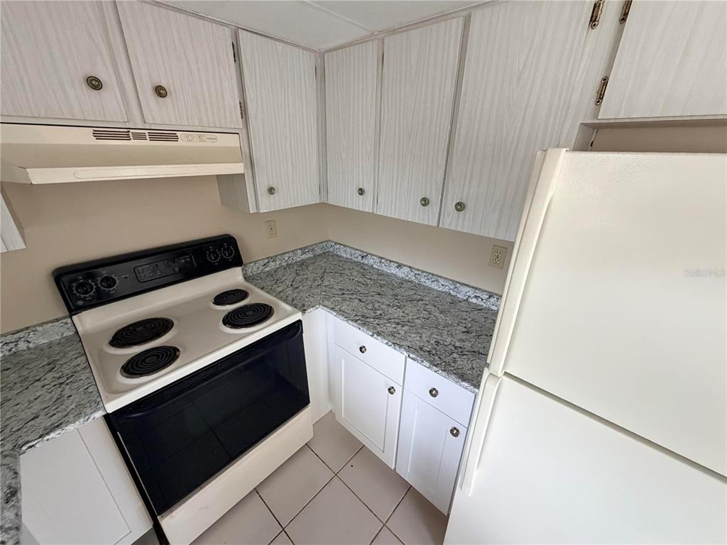 6330 Pennsylvania Avenue New Port Richey, FL 34653 - Photo 10 of 17 a kitchen with white cabinets and white appliances