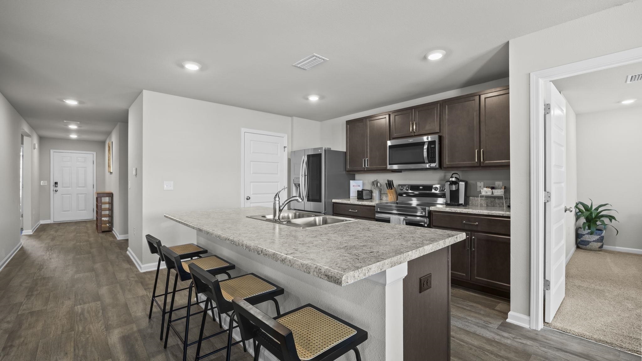 224 Burnston Way Foley, AL 36535 - Photo 6 of 42 Kitchen featuring dark brown cabinets, stainless steel appliances, recessed lighting, light countertops, and a breakfast bar
