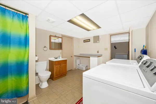 a room with a sink and a walk in closet with wooden floor