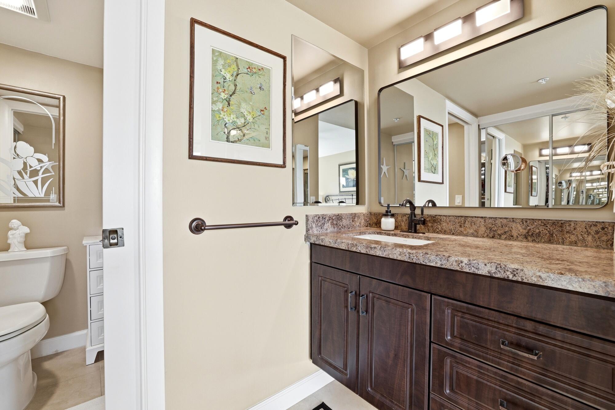 2101 Marina Isle Way, Unit 404 Jupiter, FL 33477 - Photo 7 of 17 a bathroom with a granite countertop sink mirror vanity and toilet