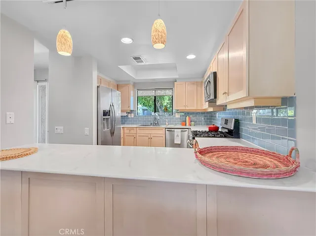 a kitchen with stainless steel appliances granite countertop a sink refrigerator and microwave