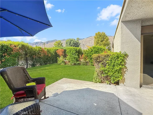 a view of a patio with a table and chairs under an umbrella