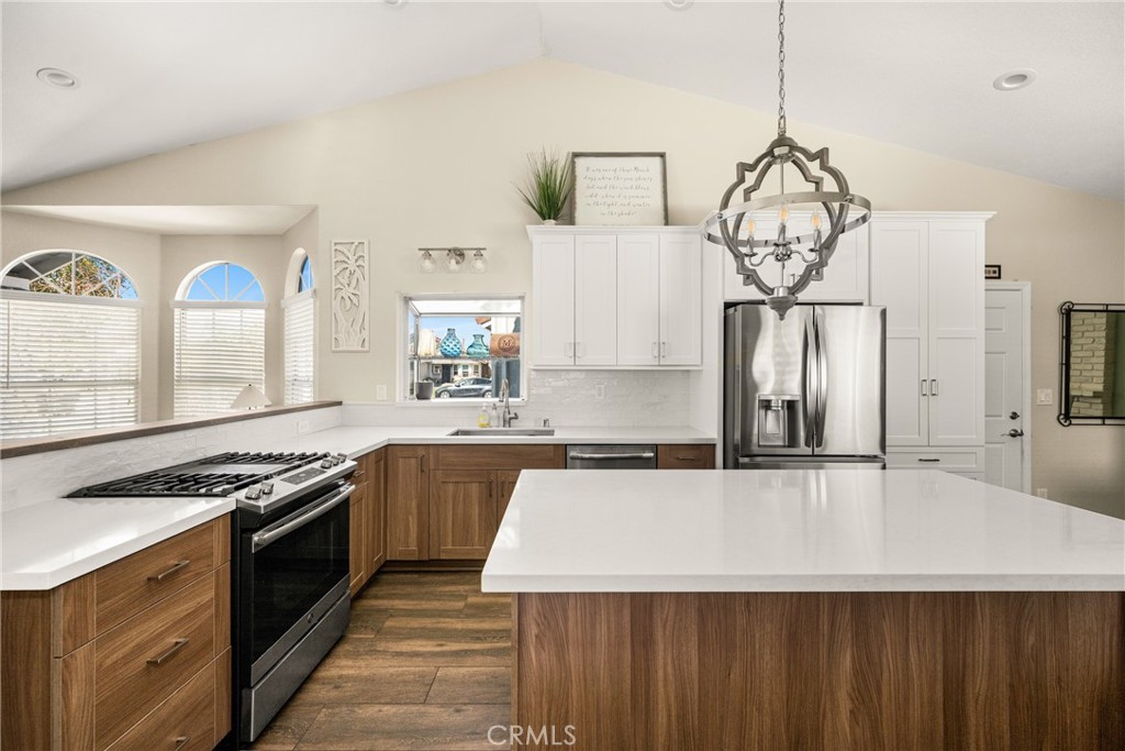 7958 East Bauer Road Anaheim, CA 92808 - Photo 11 of 45 a kitchen with stainless steel appliances a stove a sink dishwasher and white cabinets with wooden floor