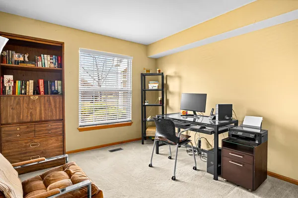a view of a workspace with furniture and a window