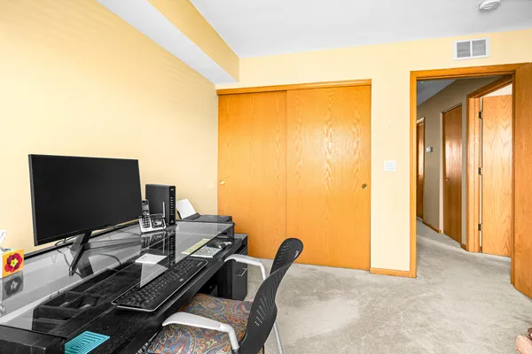 a view of a workspace with furniture and a window