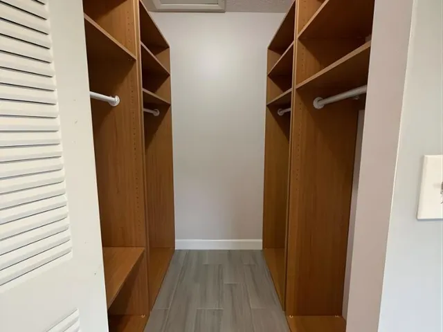 a view of walk in closet with clothes