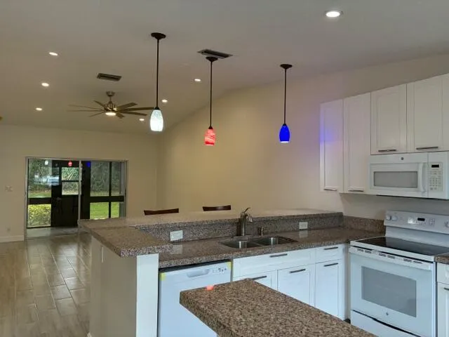 a kitchen with stainless steel appliances granite countertop a sink a stove and a wooden cabinets