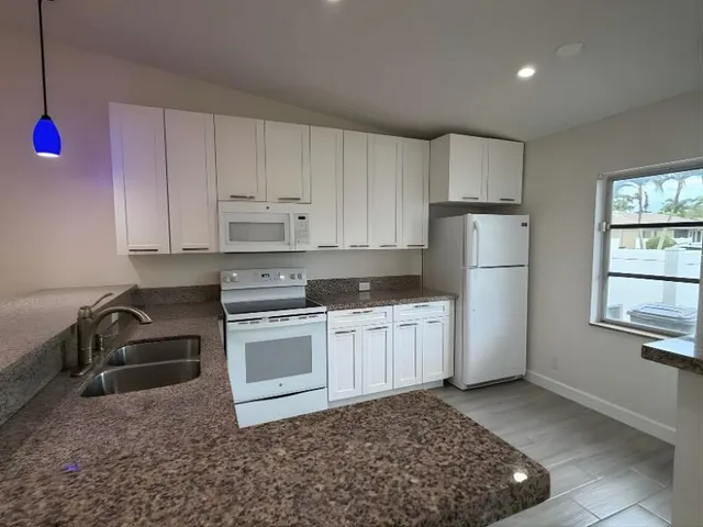 a kitchen with a sink stove and refrigerator