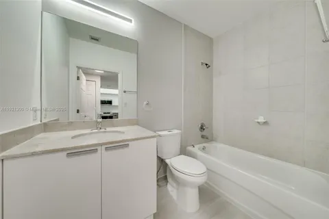 a bathroom with a granite countertop sink a toilet and bathtub