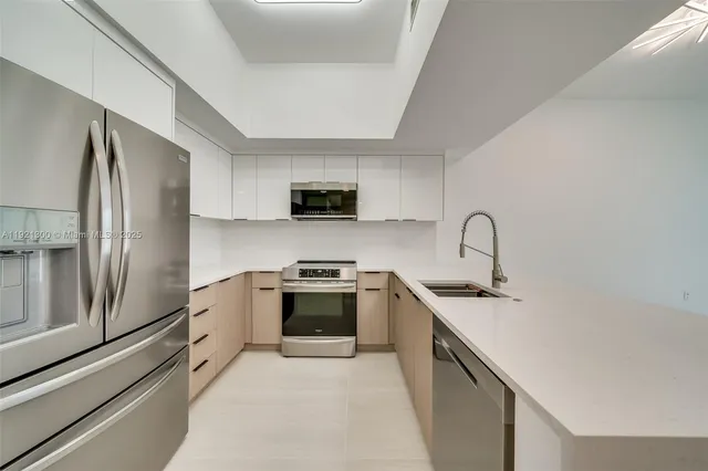 a kitchen with stainless steel appliances a sink stove refrigerator and cabinets