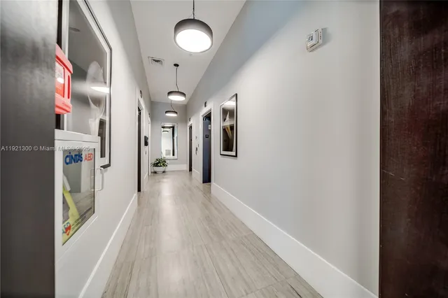 a view of a hallway with wooden floor