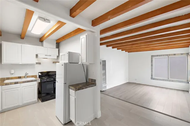a kitchen with a refrigerator and white cabinets
