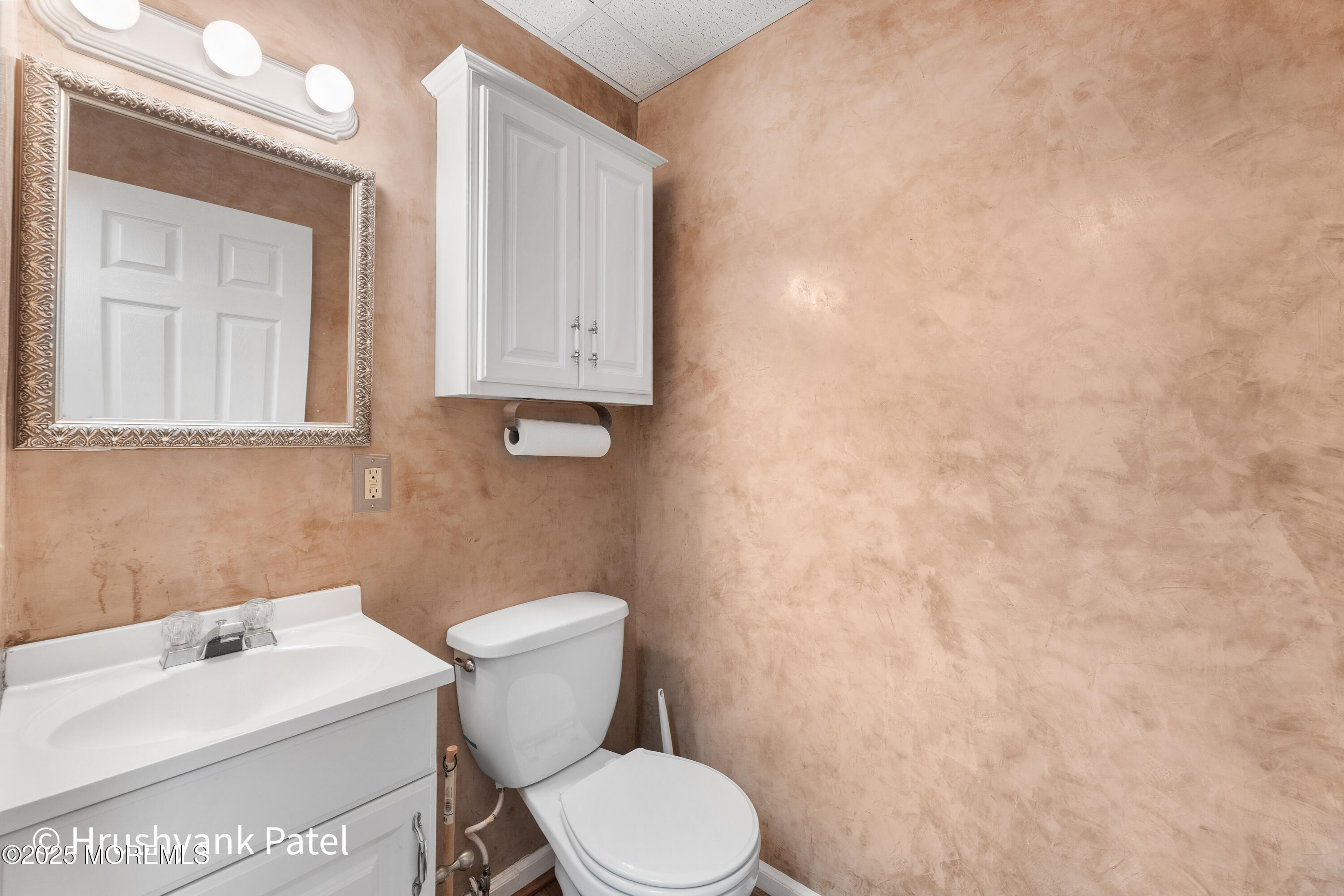 Mantoloking Road Brick, NJ 08723 - Photo 11 of 24 a white toilet sitting next to a white sink and vanity