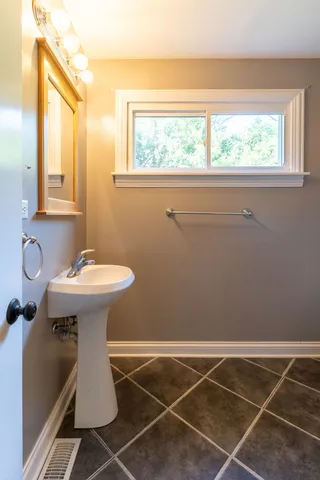 a bathroom with a sink toilet and a mirror