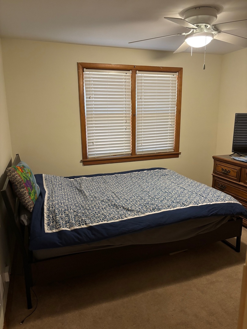 5137 South Rutherford Avenue Chicago, IL 60638 - Photo 11 of 23 a bed sitting in a bedroom next to a window