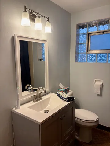 a bathroom with a toilet sink and mirror