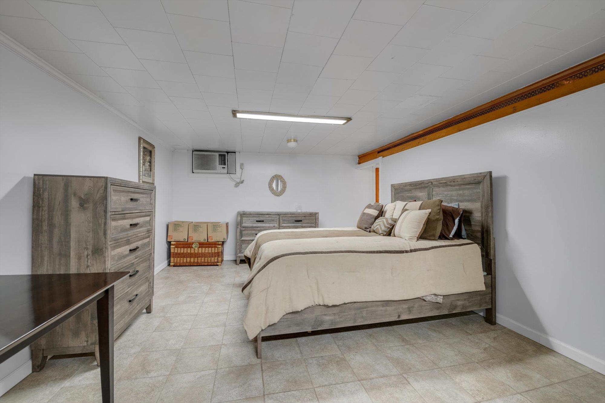 63-03 74th Street Queens, NY 11379 - Photo 14 of 15 Bedroom featuring an AC wall unit and baseboards