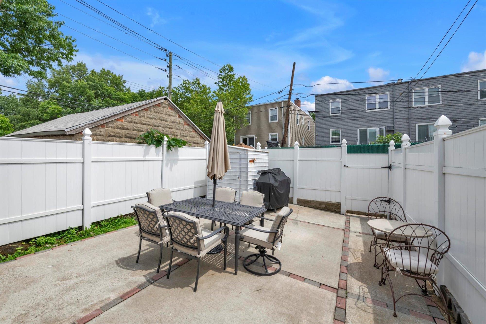 63-03 74th Street Queens, NY 11379 - Photo 15 of 15 Fenced backyard featuring outdoor dining space, a patio area, a gate, and grilling area