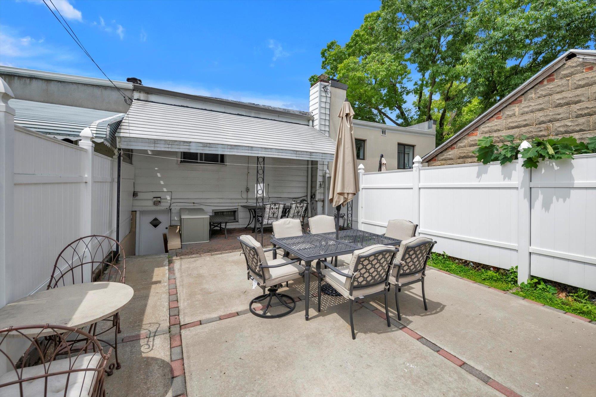 63-03 74th Street Queens, NY 11379 - Photo 3 of 15 Fenced backyard featuring outdoor dining area and a patio