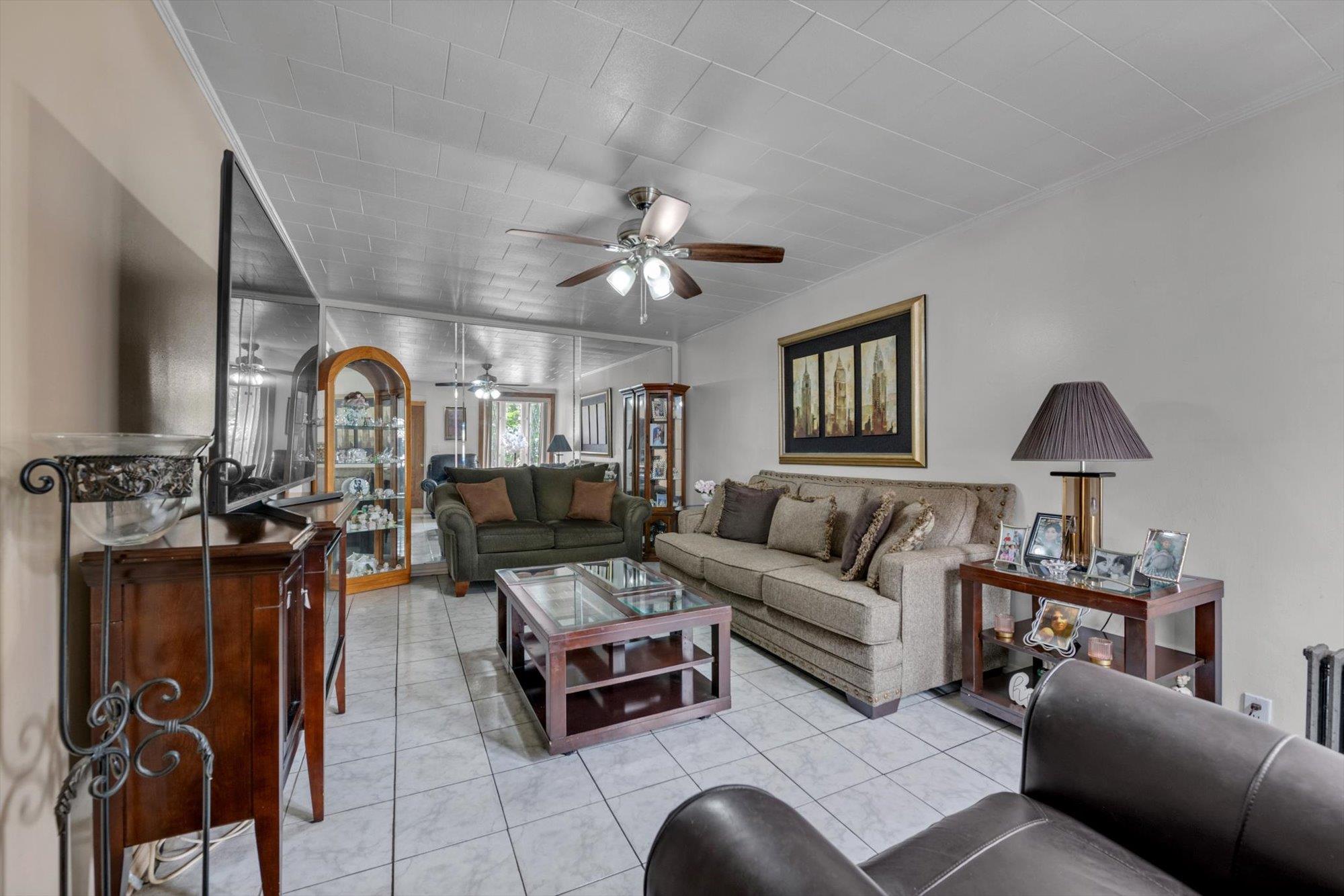 63-03 74th Street Queens, NY 11379 - Photo 5 of 15 Living area featuring ceiling fan and light tile patterned flooring
