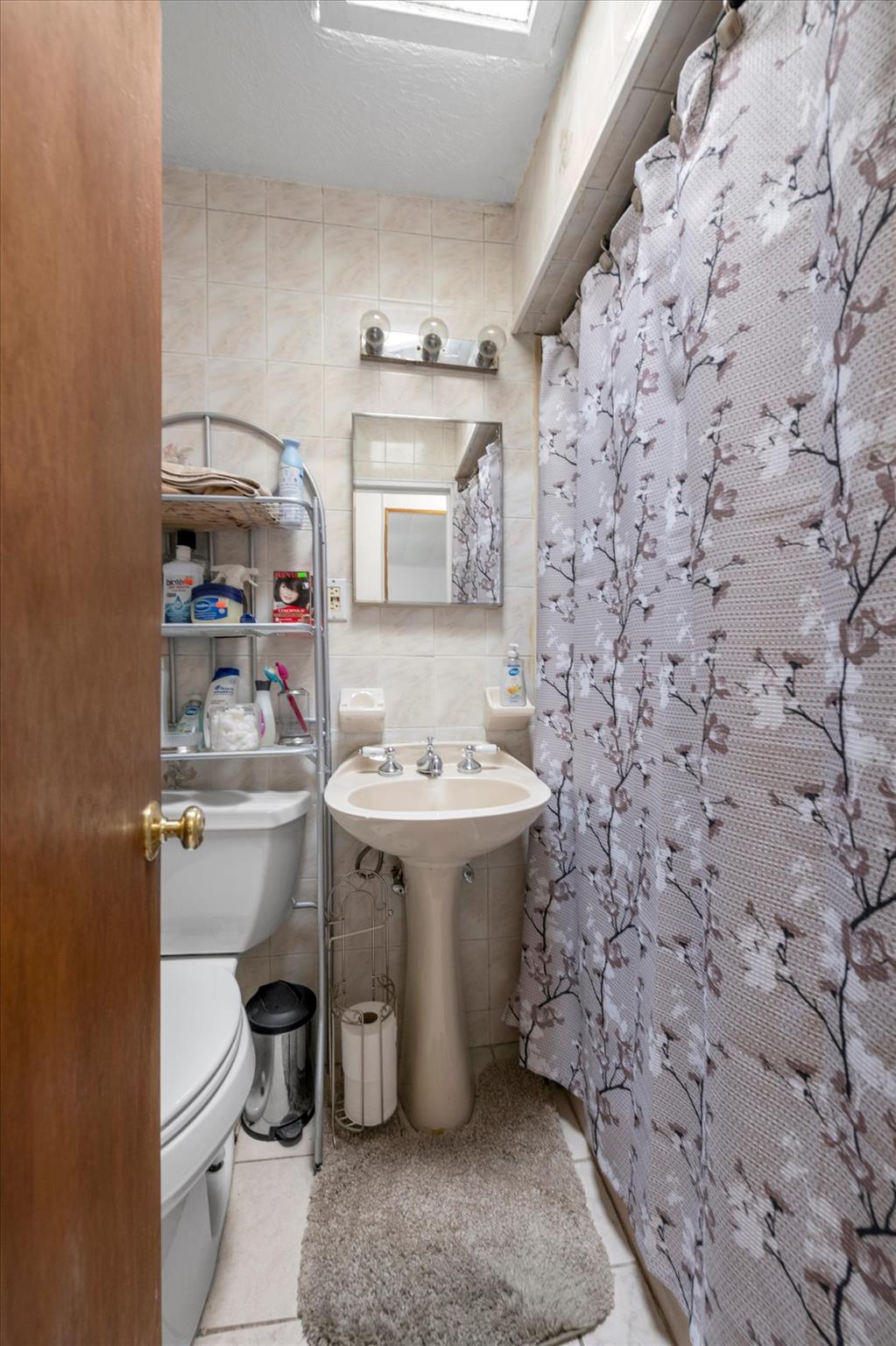 63-03 74th Street Queens, NY 11379 - Photo 10 of 15 Bathroom with tile walls, tile patterned floors, and a shower with curtain