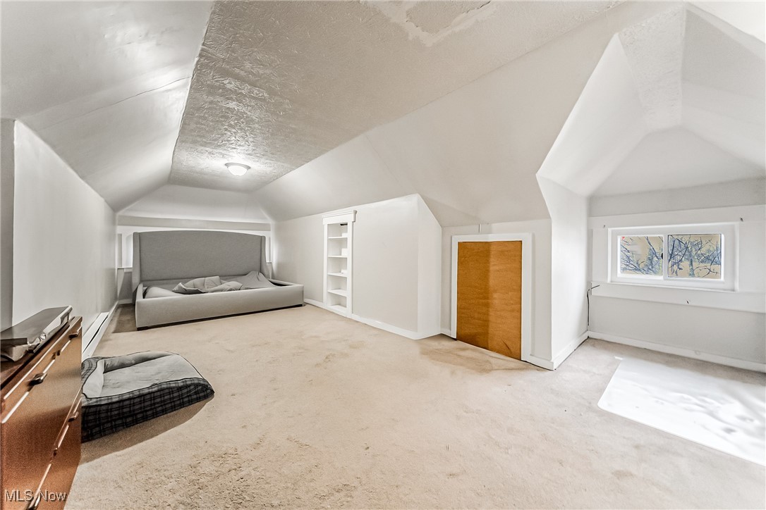 2014 Cook Avenue Cleveland, OH 44109 - Photo 23 of 37 Carpeted bedroom featuring baseboard heating, vaulted ceiling, and a textured ceiling