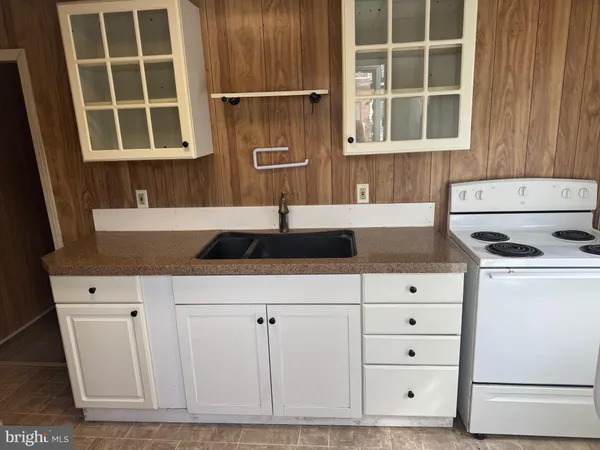 a kitchen with granite countertop white cabinets and sink