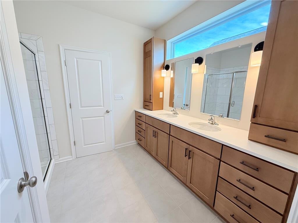 328 Abby Road, Unit LOT 15 Macungie, PA 18062 - Photo 17 of 26 A well-lit primary bath features a dual vanity and a contemporary glass-enclosed shower.