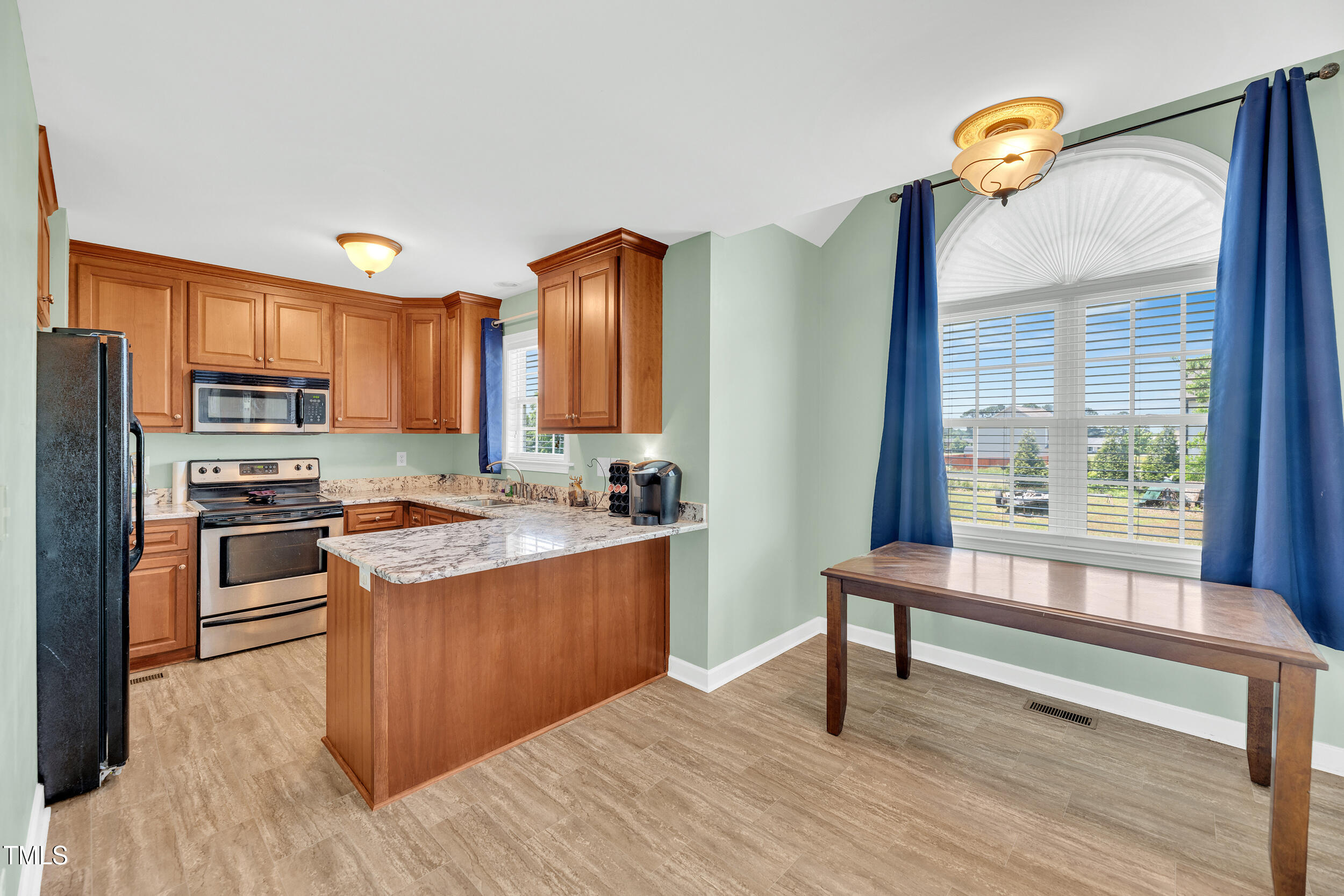 104 JJ Drive Benson, NC 27504 - Photo 13 of 20 a kitchen with stainless steel appliances granite countertop a refrigerator a stove and a wooden floors